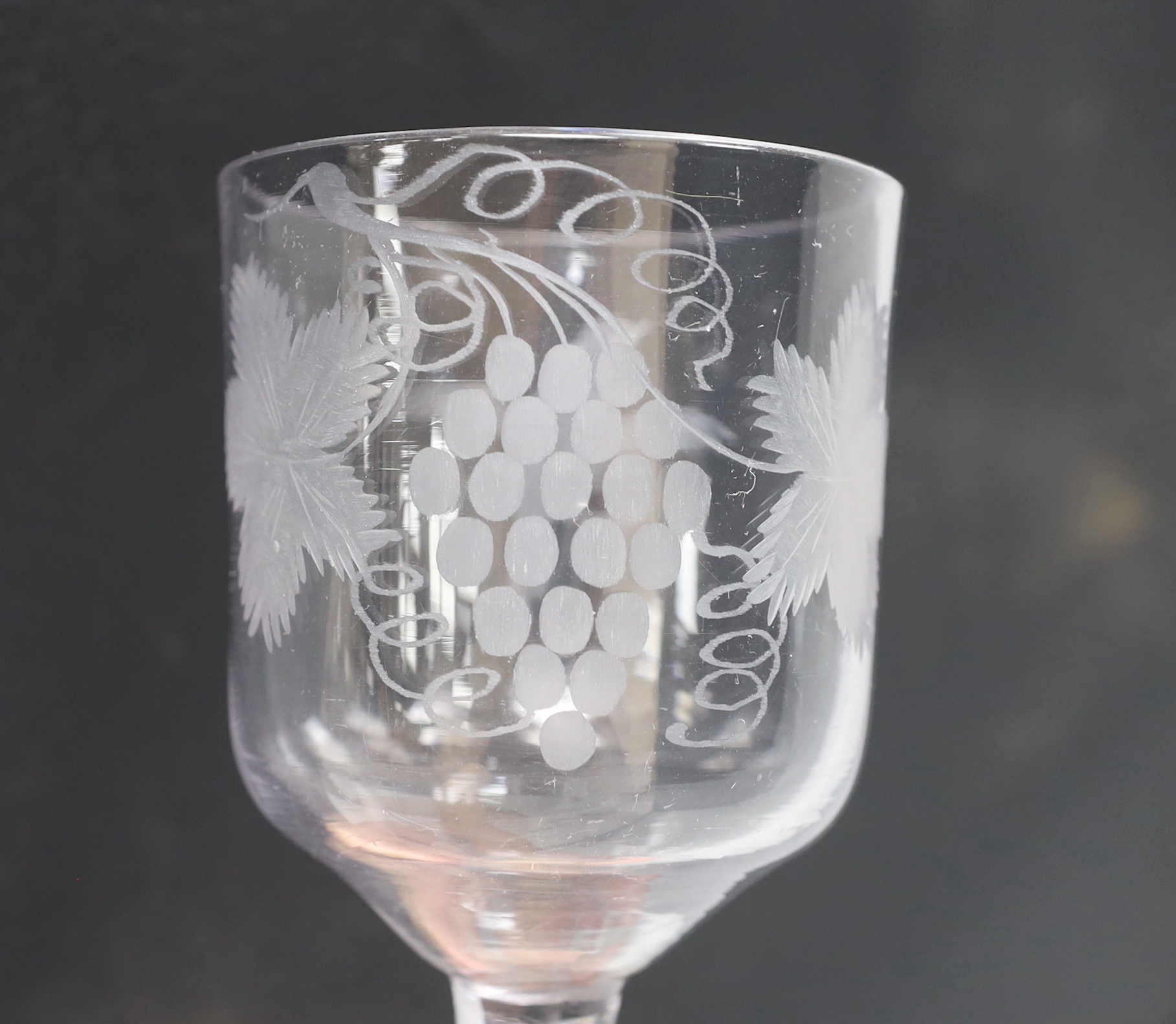 An English lead crystal goblet, c1740-50, ogee bowl with tool marks, engraved fruiting vines and a bird, with a plain stem, conical foot and rough pontil, 19.4cm